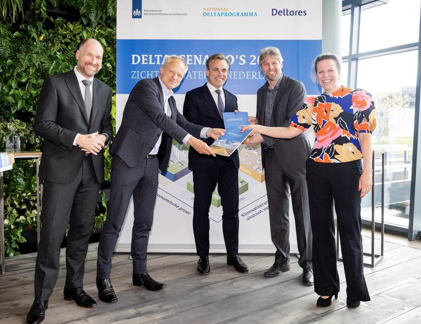 Mensen lachen en hebben samen een papier vast